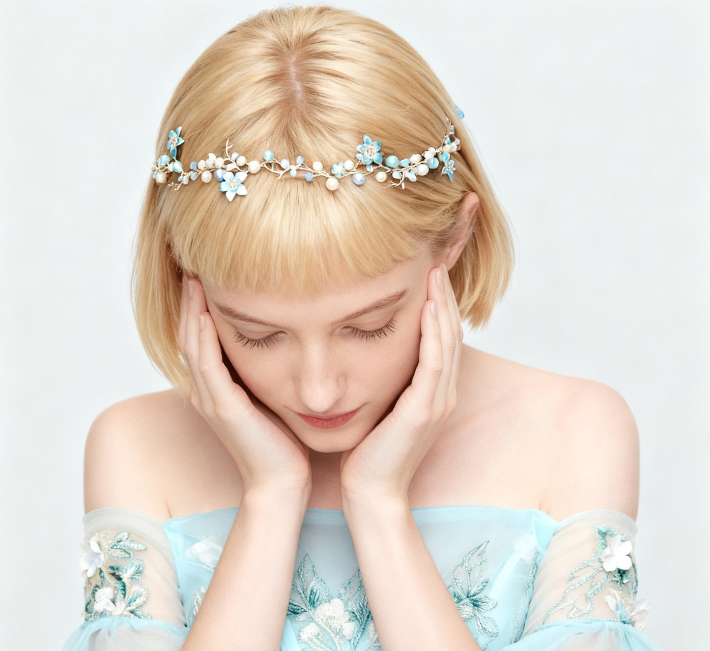 Woman wearing a floral headband and light blue dress on a white background