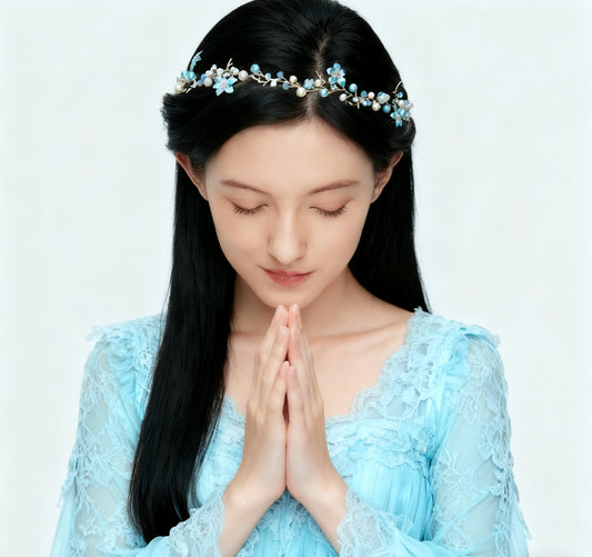 Woman in a light blue dress with floral headband on a white background
