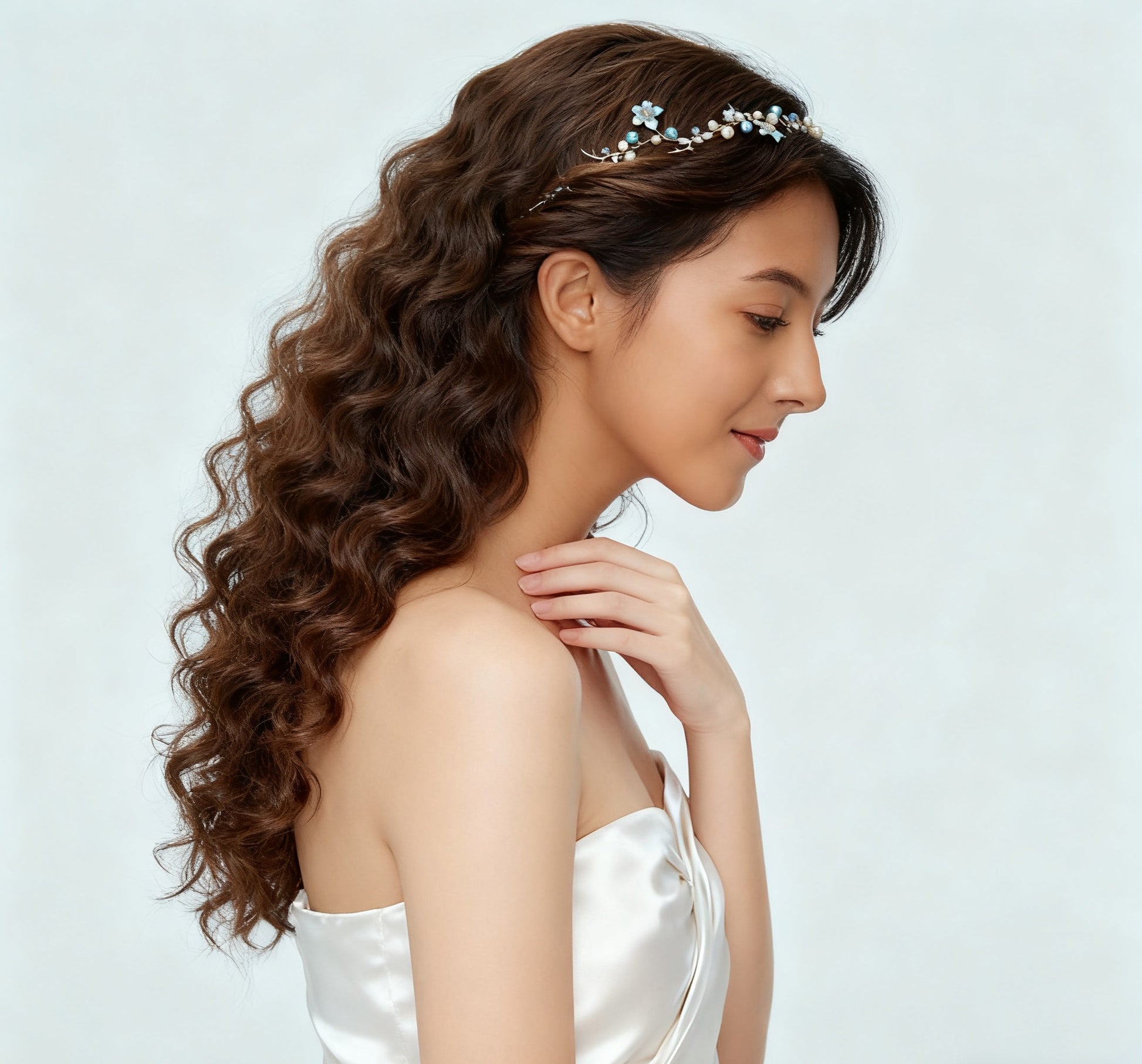 Woman with styled hair wearing a delicate headband against a light background
